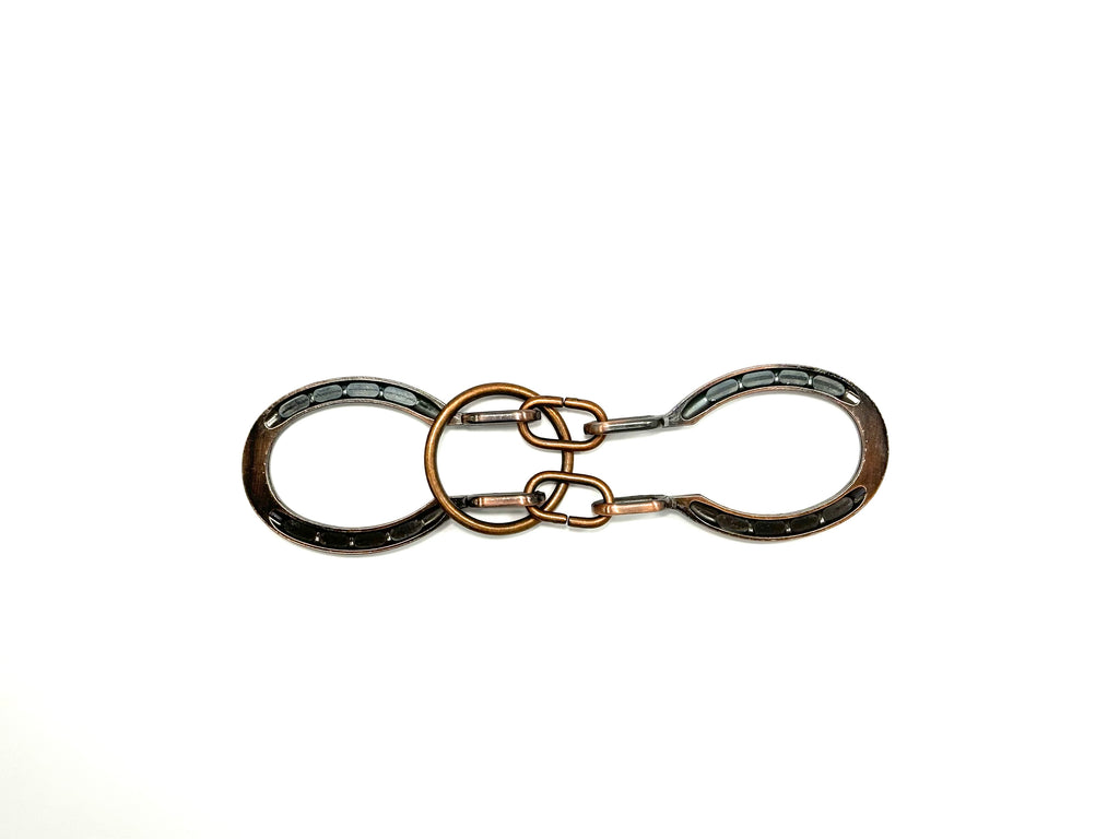 A metal puzzle with a ring in the center and cuff-like structures in silver and bronze colors.