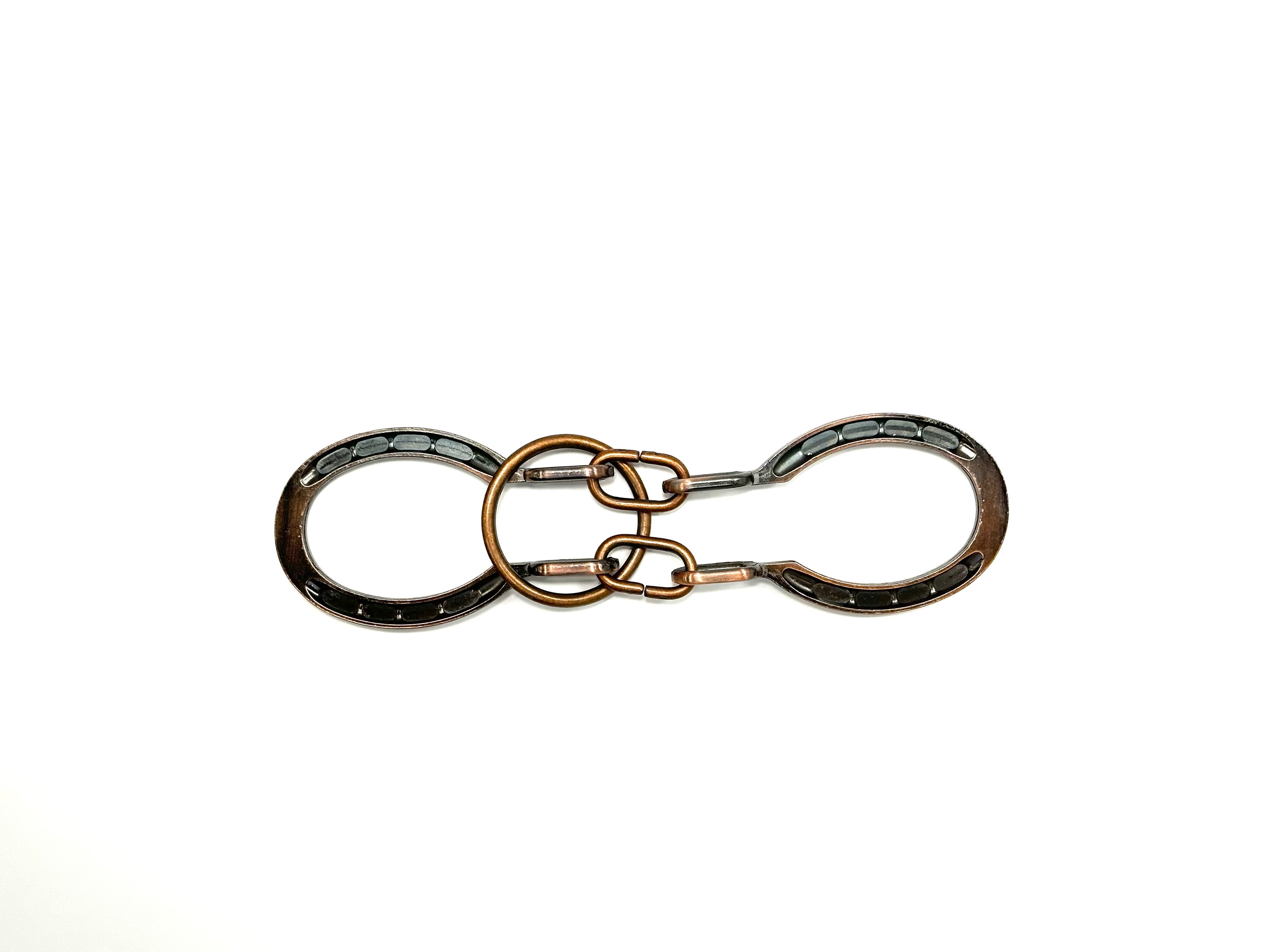 A metal puzzle with a ring in the center and cuff-like structures in silver and bronze colors.