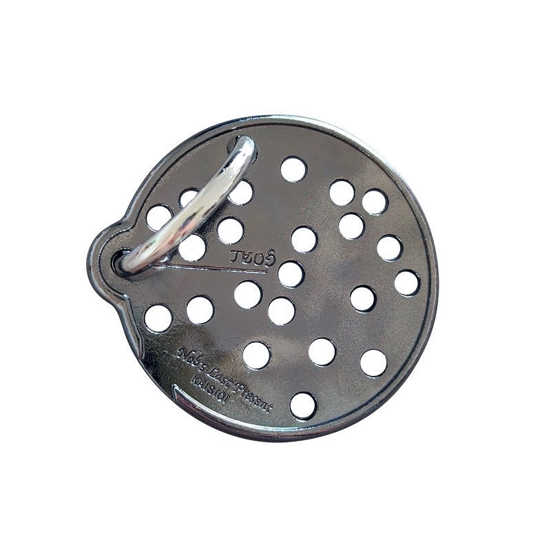 A circular metal puzzle with multiple holes and a small metal loop attached to one side.